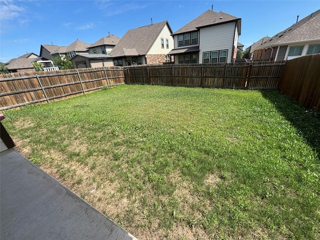 view of yard with a residential view and a fenced backyard