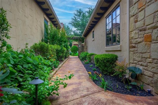 view of side of home with stone siding and stucco siding