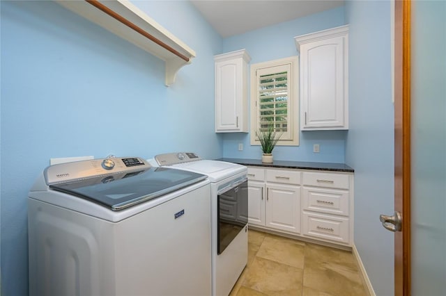 clothes washing area with independent washer and dryer, baseboards, and cabinet space