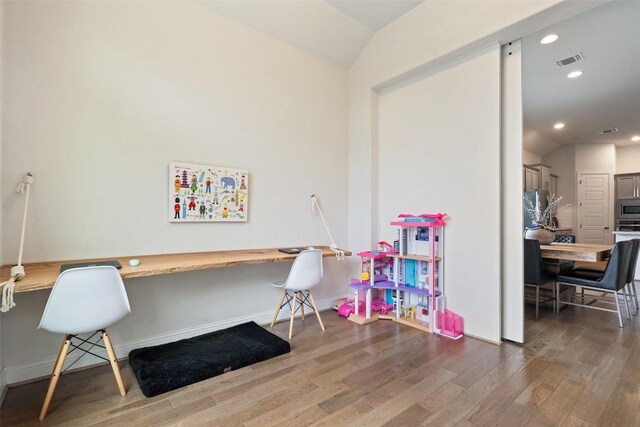 216 Vista Village Cv, Austin, TX 78738 - office area with built in desk, wood finished floors, vaulted ceiling, recessed lighting, and baseboards
