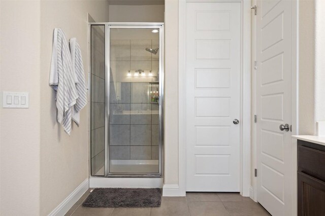 216 Vista Village Cv, Austin, TX 78738 - bathroom featuring tile patterned flooring, a stall shower, vanity, and baseboards