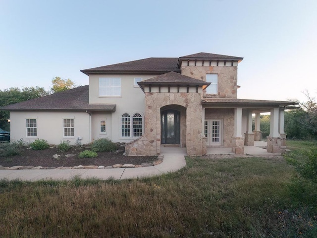 19200 White Horse Cv, Spicewood, TX 78669 - view of front facade featuring roof with shingles, a front yard, stone siding, and stucco siding