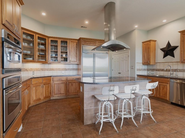 19200 White Horse Cv, Spicewood, TX 78669 - kitchen with appliances with stainless steel finishes, a sink, decorative backsplash, island exhaust hood, and visible vents