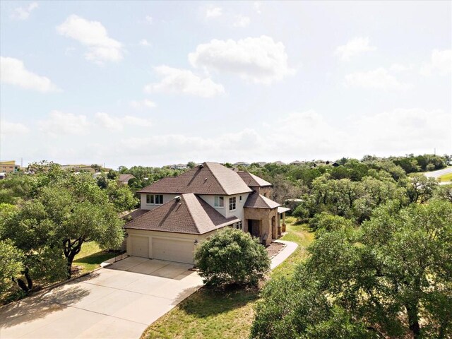 19200 White Horse Cv, Spicewood, TX 78669 - view of front of property with driveway, a garage, stucco siding, and a shingled roof
