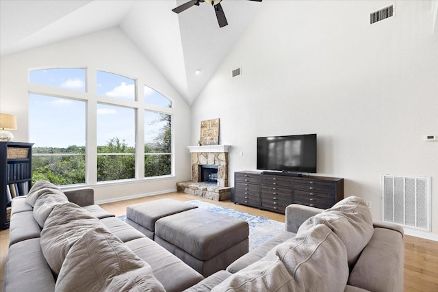 19200 White Horse Cv, Spicewood, TX 78669 - living area with ceiling fan, light wood finished floors, high vaulted ceiling, and a stone fireplace