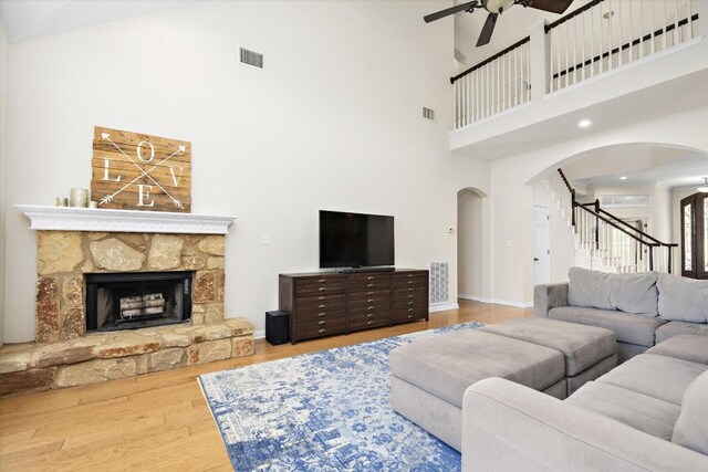 19200 White Horse Cv, Spicewood, TX 78669 - living room featuring arched walkways, a ceiling fan, a towering ceiling, wood finished floors, and stairs