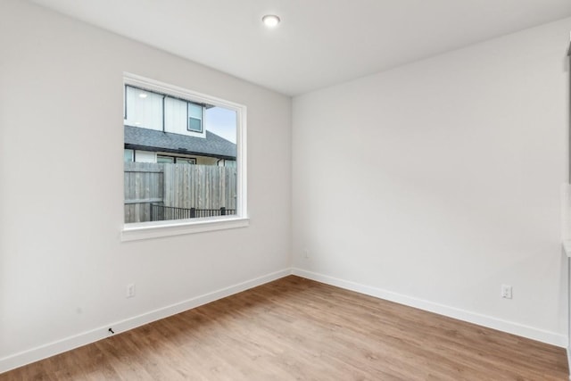 empty room with baseboards and wood finished floors