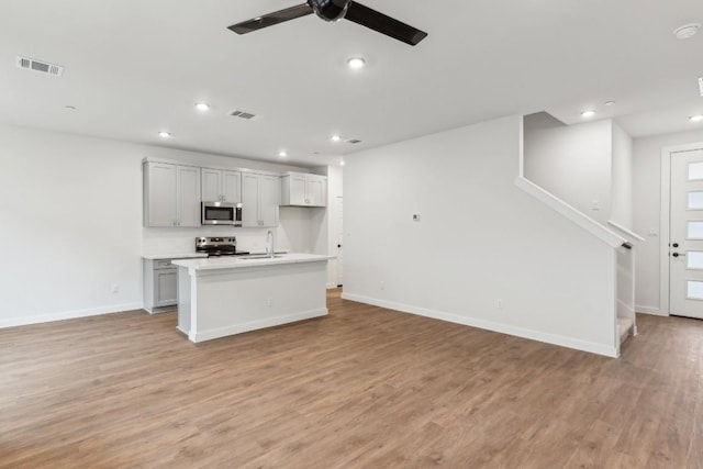 kitchen featuring visible vents, open floor plan, a sink, and stainless steel appliances