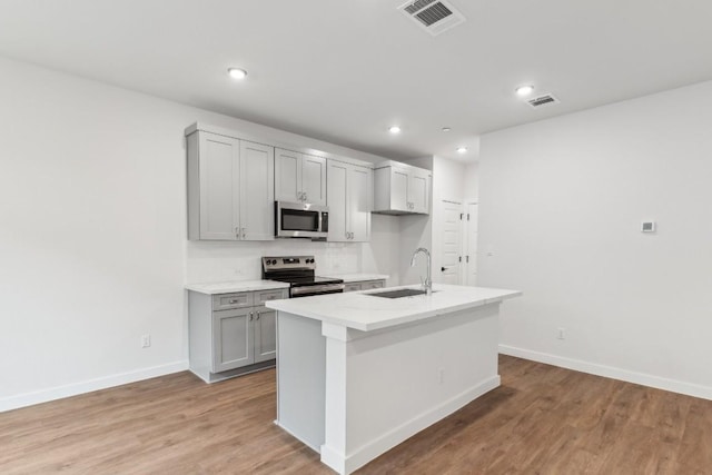 kitchen featuring visible vents, baseboards, a sink, appliances with stainless steel finishes, and gray cabinetry