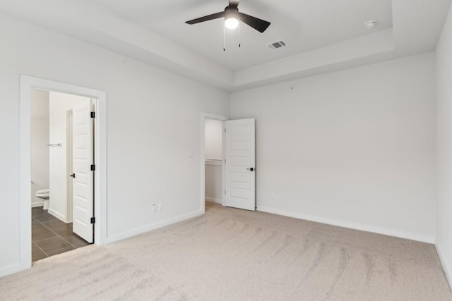 unfurnished bedroom with visible vents, carpet flooring, baseboards, and a spacious closet