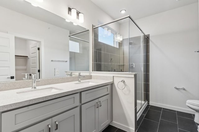 bathroom featuring a sink, tile patterned flooring, a shower stall, and double vanity