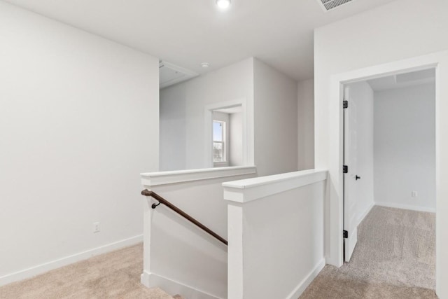 corridor with attic access, baseboards, an upstairs landing, and carpet