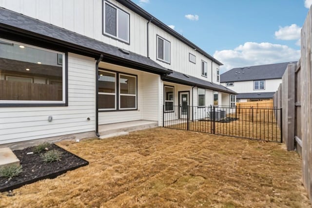 back of house with a fenced backyard, a patio, board and batten siding, and central AC unit