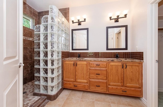 411 Brazos Dr, Georgetown, TX 78628 - full bath with walk in shower, double vanity, tile patterned floors, and tasteful backsplash