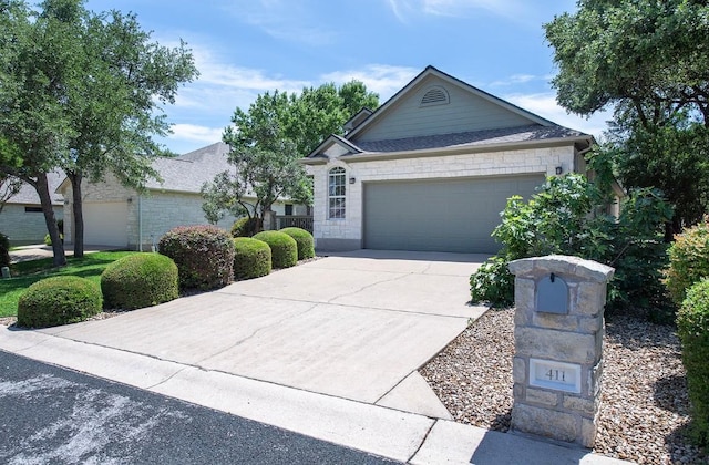 411 Brazos Dr, Georgetown, TX 78628 - view of front of property featuring a garage, driveway, and stone siding
