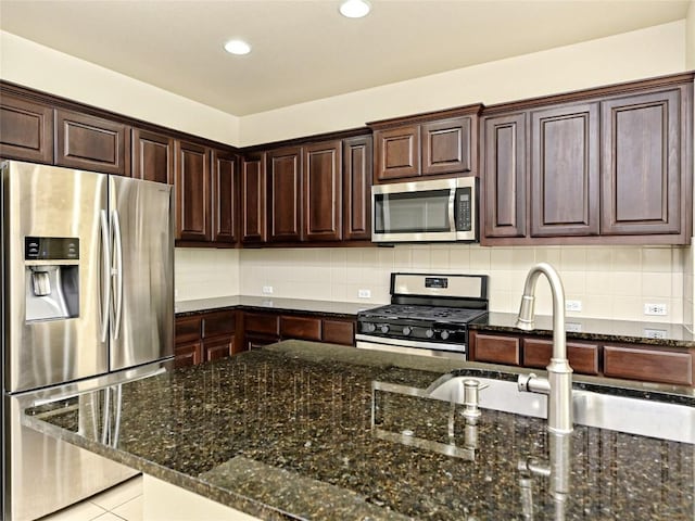 kitchen with dark brown cabinetry, backsplash, dark stone countertops, stainless steel appliances, and recessed lighting