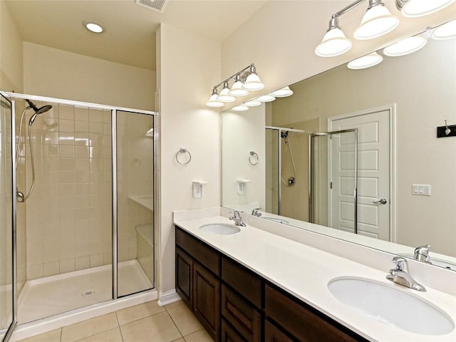 bathroom featuring a sink, tile patterned flooring, a shower stall, and double vanity