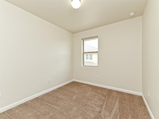 carpeted empty room featuring baseboards