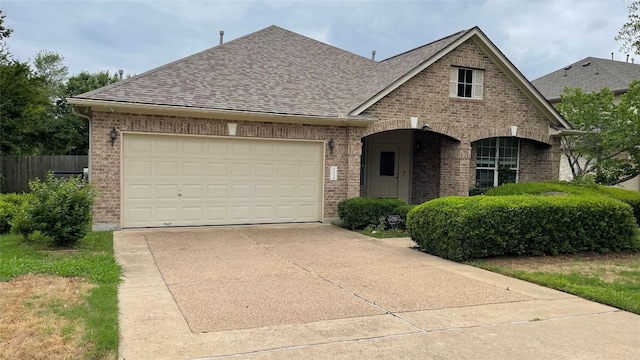 2305 Amen Corner Rd, Pflugerville, TX 78660 - view of front of home with roof with shingles, fence, an attached garage, brick siding, and concrete driveway