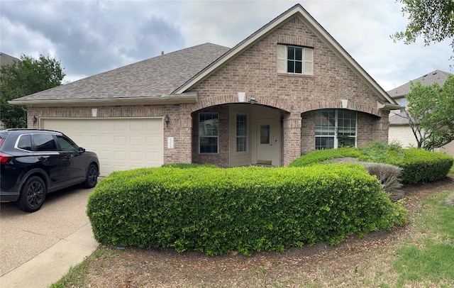 2305 Amen Corner Rd, Pflugerville, TX 78660 - view of front of property with brick siding, an attached garage, roof with shingles, and concrete driveway