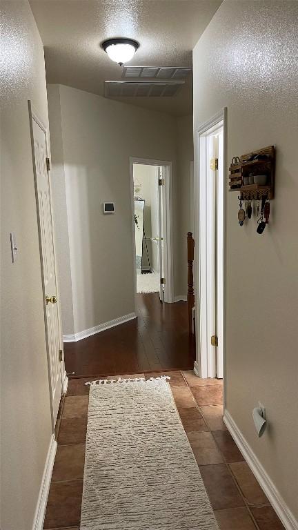 2305 Amen Corner Rd, Pflugerville, TX 78660 - hall featuring dark tile patterned floors, baseboards, and visible vents