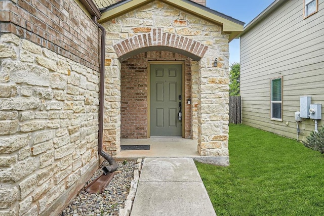 9504 Southwick Dr, Austin, TX 78724 - doorway to property with stone siding and a yard