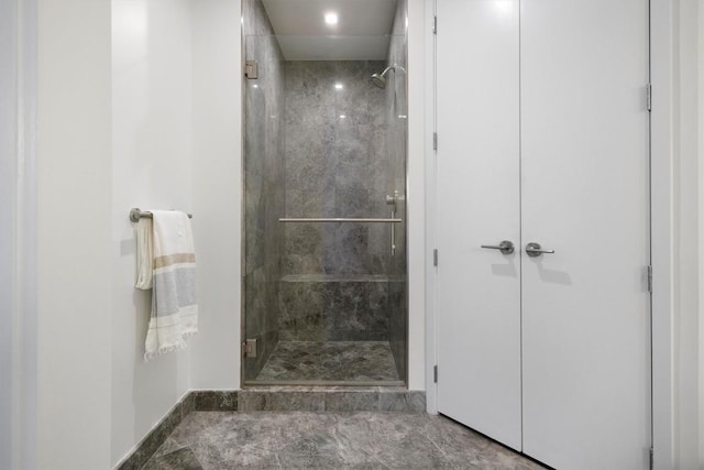 bathroom with baseboards and a shower stall
