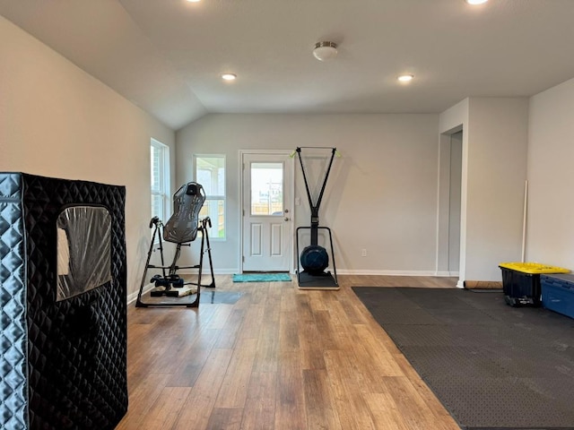exercise room with baseboards, recessed lighting, lofted ceiling, and wood finished floors