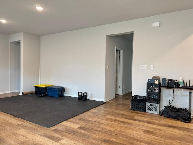 interior space with baseboards, recessed lighting, and wood finished floors