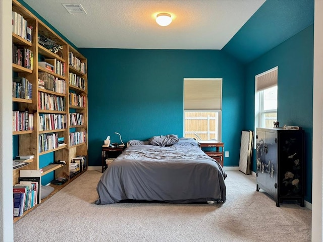 carpeted bedroom with baseboards, visible vents, and lofted ceiling
