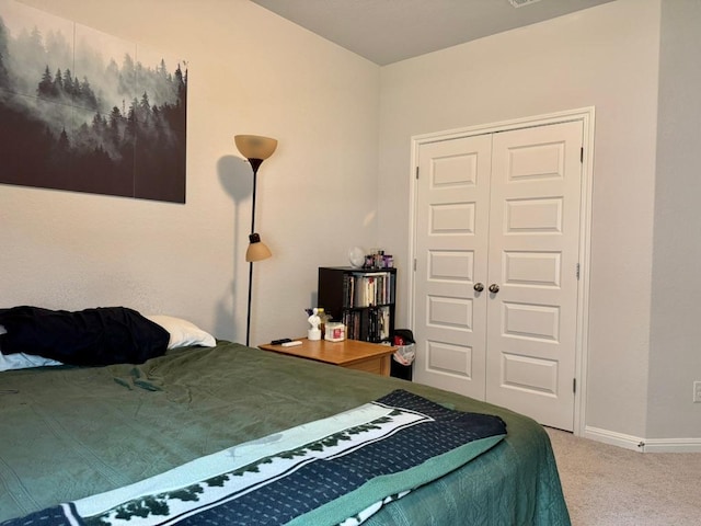 carpeted bedroom featuring a closet and baseboards