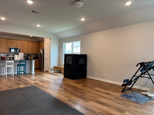 interior space featuring dark wood-style flooring, recessed lighting, baseboards, lofted ceiling, and visible vents