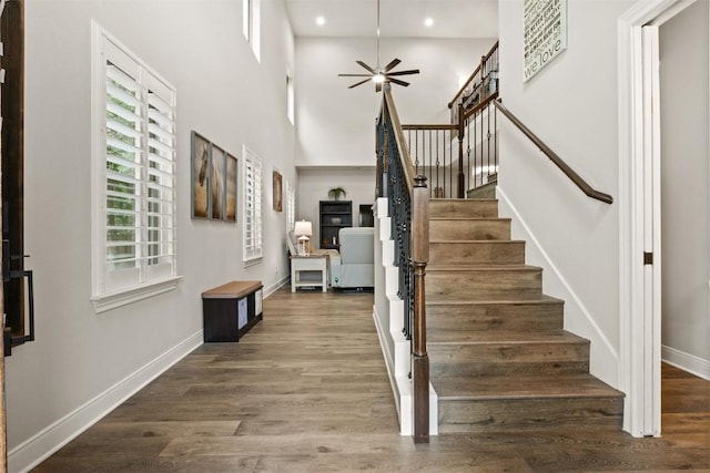 staircase featuring baseboards, ceiling fan, recessed lighting, and wood finished floors