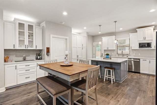 kitchen featuring a sink, stainless steel appliances, recessed lighting, and white cabinetry