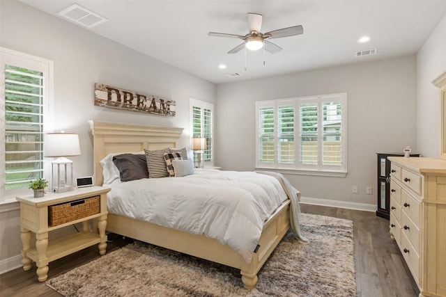 bedroom featuring visible vents, dark wood-style flooring, and baseboards