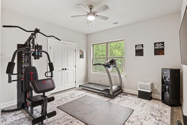 workout room with baseboards, visible vents, and ceiling fan