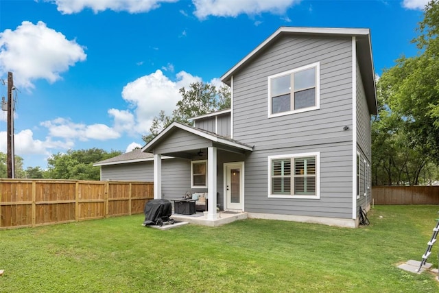 rear view of property featuring a yard, a patio, a ceiling fan, and a fenced backyard