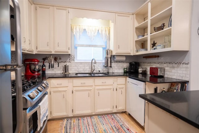 913 Fowzer St, Taylor, TX 76574 - kitchen with gas range, dark countertops, tasteful backsplash, dishwasher, and a sink