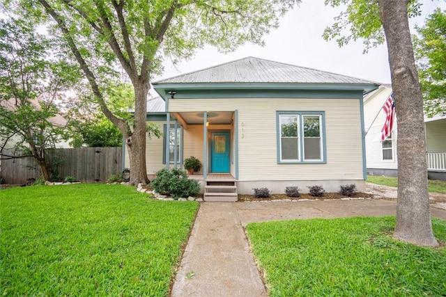 913 Fowzer St, Taylor, TX 76574 - bungalow with fence, covered porch, a front yard, and metal roof