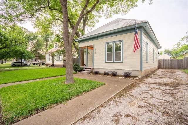 913 Fowzer St, Taylor, TX 76574 - view of front of home featuring fence, metal roof, driveway, and a front yard
