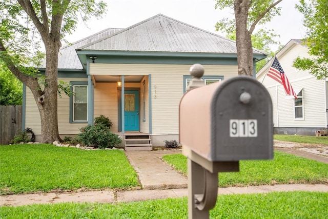 913 Fowzer St, Taylor, TX 76574 - view of front facade with fence, metal roof, and a front lawn
