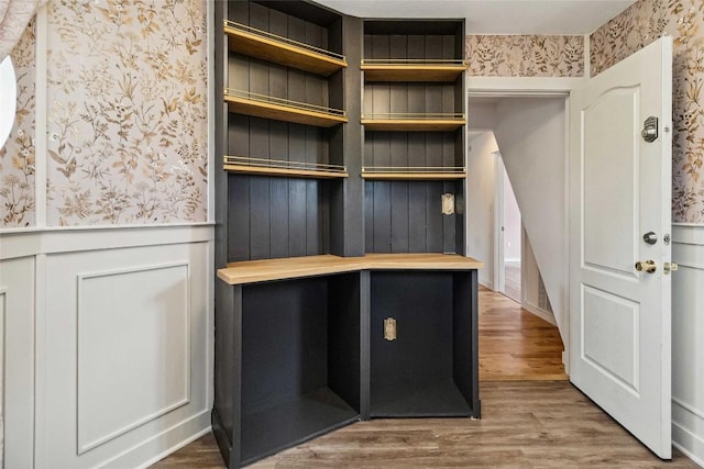 mudroom featuring wainscoting, wood finished floors, and wallpapered walls