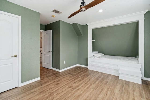 unfurnished bedroom featuring visible vents, baseboards, ceiling fan, and wood finished floors