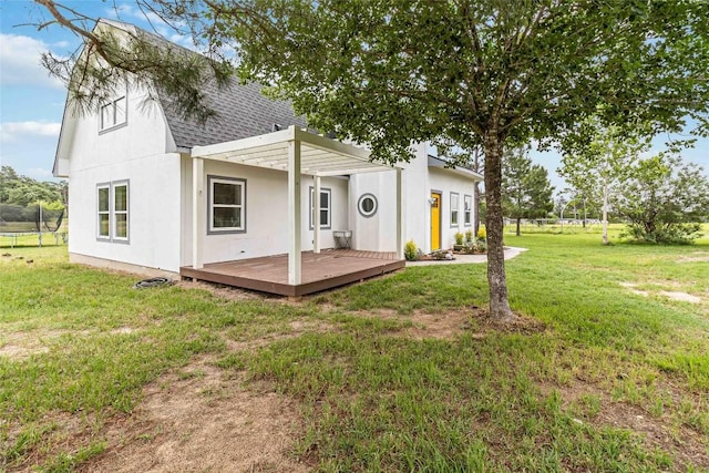 back of property featuring a lawn, a shingled roof, and a wooden deck