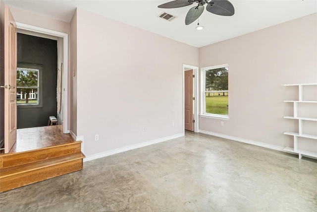 unfurnished living room with a ceiling fan, baseboards, visible vents, and finished concrete flooring