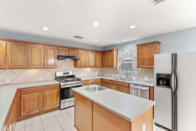 1564 Lorson Loop, Round Rock, TX 78665 - kitchen with stainless steel appliances, under cabinet range hood, a center island with sink, light countertops, and backsplash