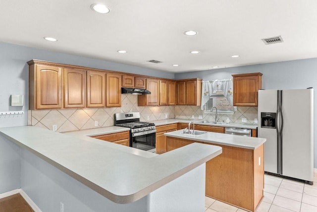 1564 Lorson Loop, Round Rock, TX 78665 - kitchen featuring stainless steel appliances, under cabinet range hood, a kitchen island with sink, light countertops, and a peninsula