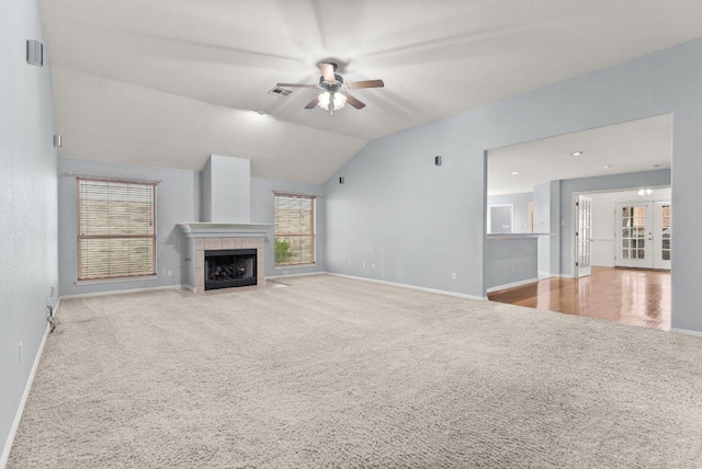 1564 Lorson Loop, Round Rock, TX 78665 - unfurnished living room featuring carpet, a ceiling fan, french doors, a tiled fireplace, and vaulted ceiling