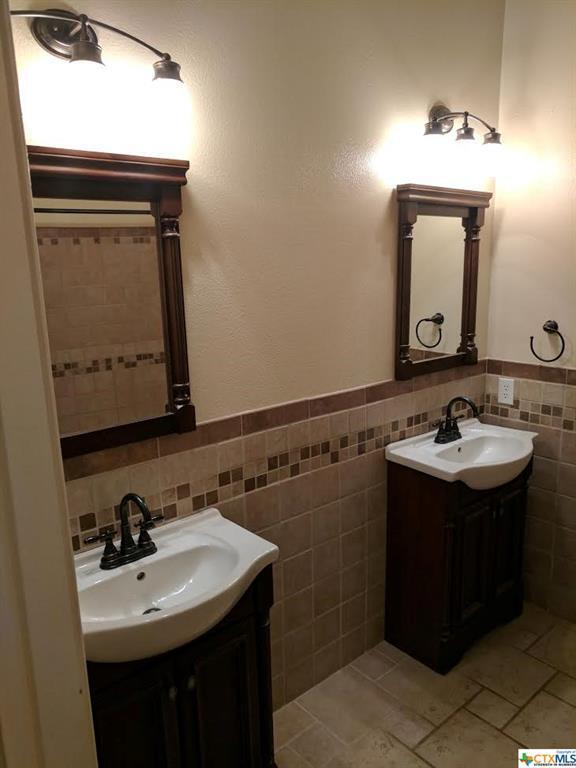 1502 Stratford Dr, Killeen, TX 76549 - bathroom featuring vanity, tile walls, tile patterned floors, and wainscoting