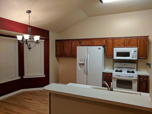 1502 Stratford Dr, Killeen, TX 76549 - kitchen with white appliances, a chandelier, vaulted ceiling, wood finished floors, and decorative light fixtures